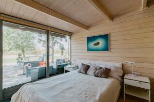 a bedroom with a bed and a large window at Zam-zam apartman in Zamárdi