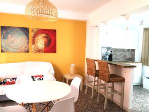 a dining room with yellow walls and a table and chairs at LA COLONIA PLAYA in Águilas