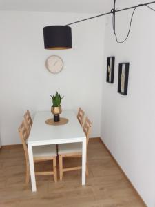 a white dining room table with chairs and a potted plant at Complex Apartamenty - Golden in Koszalin