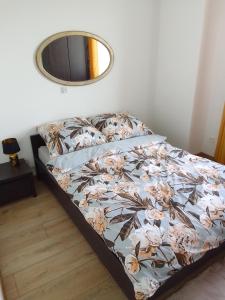 a bed in a bedroom with a mirror on the wall at Complex Apartamenty - Golden in Koszalin