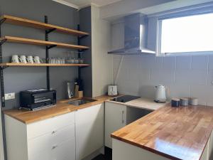 a kitchen with white cabinets and a counter top with a microwave at Private 2 bedrooms suite with free parking in Rotorua