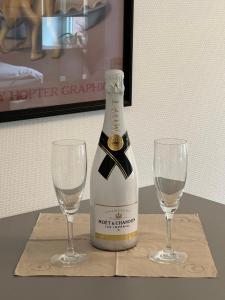 Una botella de champán y dos copas en una mesa. en Traumhafte luxuriöse Ferienwohnungen im wunderschönen St. Blasien en St. Blasien