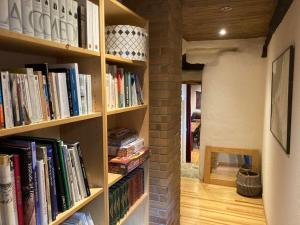 una mensola piena di libri in una stanza di Maison rurale au cœur des Cévennes Ardéchoises a Dompnac