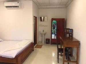 een slaapkamer met een bed, een bureau en een tafel bij Nam Thanh Homestay in Vĩnh Long