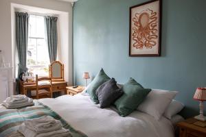 1 dormitorio con 1 cama con almohadas verdes y blancas en Three Tuns, en Helston