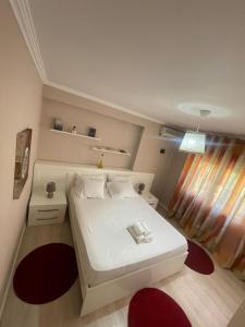 een kleine slaapkamer met een wit bed en een raam bij Apartment Centre View New Bazaar in Tirana