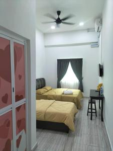 1 dormitorio con 2 camas y ventilador de techo en Kangar Jaya Lodging, en Kangar