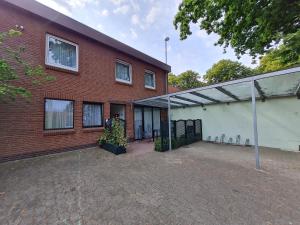 a red brick building with a white garage at Haus Ekke Nekkepenn II, Haus Ekke Nekkepenn II, Whg D1 in Wyk auf Föhr