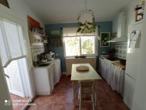una cocina con una mesa con una pizza. en Pareado en Loma Sancti Petri a 900 m de la playa de La Barrosa en Chiclana de la Frontera