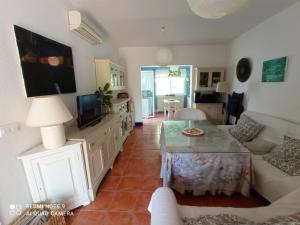sala de estar con sofá y mesa en Pareado en Loma Sancti Petri a 900 m de la playa de La Barrosa en Chiclana de la Frontera