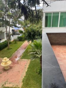 a backyard of a house with a garden and a building at Résidence SUN SET BEACH à 200 m de mer in Mohammedia