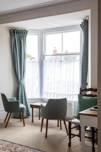 a living room with chairs and a table and windows at Three Tuns in Helston