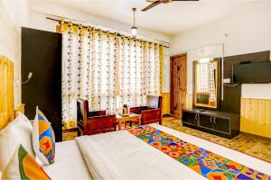 a bedroom with a bed and a television in a room at FabHotel The Countryside B and B in Manāli