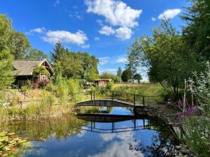 a bridge over a river in a field at Ferienhaus Mayland in Humptrup