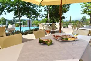 uma mesa com um prato de comida e copos de vinho em Agricampeggio Corte Tonolli em Valeggio sul Mincio