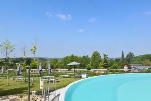 a swimming pool with chairs and umbrellas in a park at Agricampeggio Corte Tonolli in Valeggio sul Mincio