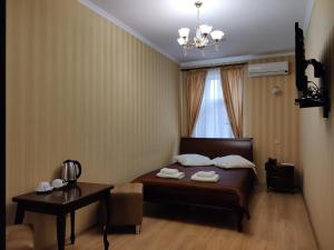 a bedroom with a bed and a table and a window at Evropeyskiy in Kyiv