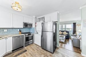 a kitchen with white cabinets and a stainless steel refrigerator at Gulf View 27 in Gulf Shores
