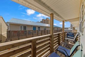 a deck with chairs and awnings on a house at Gulf View 27 in Gulf Shores