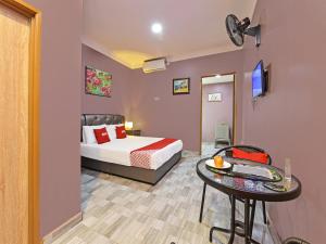 a bedroom with a bed and a table in a room at OYO Home 90348 Inspire Rooms in Pantai Cenang