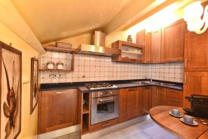 eine Küche mit Holzschränken und einem Herd mit Backofen in der Unterkunft San Marco Elegante Panoramico Esclusivo 2 bagni in Venedig