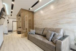 sala de estar con sofá marrón y pared en New York Concept House Cozy apartment, en Kiev
