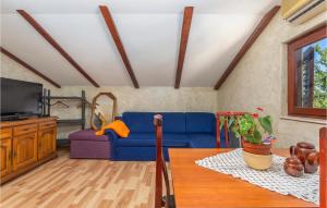 a living room with a blue couch and a table at Nice Apartment In Njivice With Wifi in Njivice