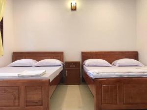 twee bedden naast elkaar in een kamer bij Nam Thanh Homestay in Vĩnh Long
