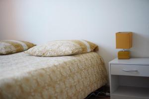 ein Bett mit zwei Kissen darauf mit einem Nachttisch in der Unterkunft Petit appartement cosy à Troyes in Troyes