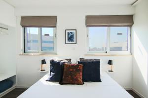 a bedroom with a white bed with two windows at Phaedrus Living: Luxury Suite Nicosia 503 in Nicosia