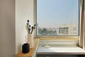 Phaedrus Living: Luxury Suite Nicosia 503 في نيقوسيا: طاولة مطبخ مع نافذة ومغسلة