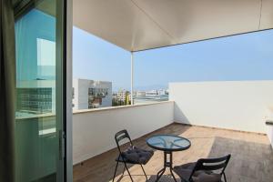 Phaedrus Living: Luxury Suite Nicosia 503 في نيقوسيا: طاولة زجاجية وكراسي في غرفة مطلة