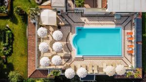 una vista aérea de una piscina con sombrillas blancas en Hotel Arena en Sirmione