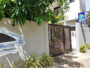 biały płot z bramą i roślinami w obiekcie Mila Rest Garden w mieście Mirissa