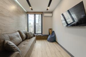 uma sala de estar com um sofá e uma grande janela em New York Concept House Cozy apartment em Kiev