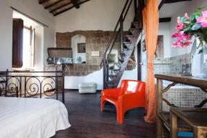 a room with a bed and a red chair at Vinto House Civita in Bagnoregio