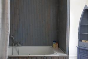 a bath tub in a bathroom with a shower at L'Hermine in Spa +26 photos