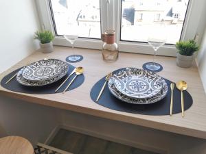 dos platos y tenedores y cucharas en una mesa en Dieppe, Studio cosy front de mer, en Dieppe