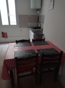 een keuken met een tafel, 2 stoelen en een wastafel bij antoinette in Carcassonne