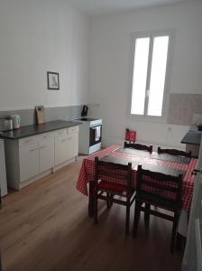 een keuken met een tafel en stoelen in een kamer bij antoinette in Carcassonne