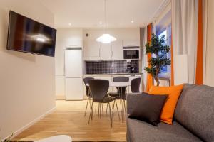 een woonkamer en een keuken met een bank en een tafel bij ApartDirect Solna in Solna