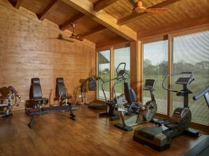 une salle de sport avec plusieurs tapis de course et machines elliptiques dans l'établissement Villa Abbondanzi Resort, à Faenza