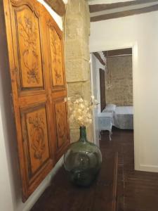 un jarrón sentado en una mesa junto a una puerta de madera en El Desván del Campanero apartamento con jardín, en Murillo de Gállego