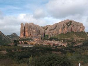 a mountain range with a village in front of it at El Desván del Campanero apartamento con jardín in Murillo de Gállego +34 photos