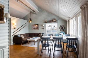 a dining room and living room with a table and chairs at Eliassen Rorbuer in Reine