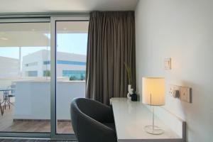 a room with a desk with a chair and a window at Phaedrus Living: Luxury Suite Nicosia 504 in Nicosia
