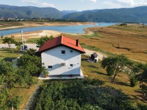 une vue aérienne sur une maison blanche avec un toit rouge dans l'établissement Vikendica Bošnjak, à Prozor