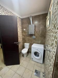 a bathroom with a toilet and a washing machine at Dokki Apartments in Cairo