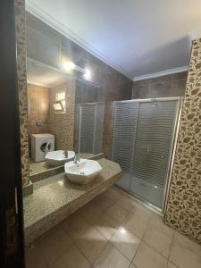 a bathroom with two sinks and a large mirror at Dokki Apartments in Cairo