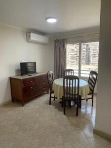 a living room with a table and chairs and a television at Dokki Apartments in Cairo